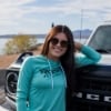 Woman wearing Mercury Racing Storm Creek Women’s Hooded Long Sleeve in front of Ford Bronco