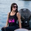 Woman wearing Women’s Mercury Racing Velocity Tank in front of Mercury engine on the water