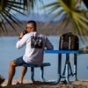 Man on picnic table with Mercury Racing cooler bag on table