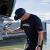 Man wearing Mercury Racing Stripes Performance Tee inspecting a propellor