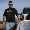Man wearing Mercury Racing Stripes Performance Tee touching a boat
